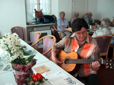 Seniorinnen beim Singen mit Gitarrenbegleitung