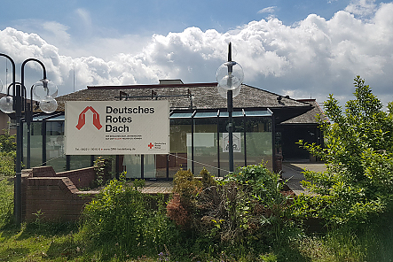 Außenansicht des Mutter-Kind-Hauses mit Schild - Deutsches Rotes Dach