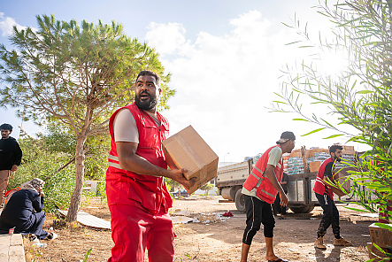 Helfer vom Libyschen Roten Halbmond bilden eine Kette beim Ausladen von Hilfsgütern