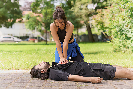 Erste Hilfe Situation. Der Mann ist beim Joggen zusammengebrochen. Die Frau beginnt mit der Herz-Lungen-Wiederbelebung