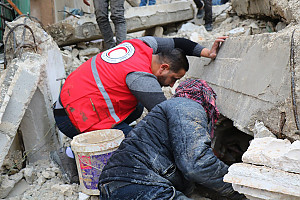 Erdbeben der Stärke 7,8 in Syrien und der Südost-Türkei: Helfer vom Syrischen Arabischen Roten Halbmond und Bewohner suchen in den Trümmern eines zusammengestürzten Hauses nach Überlebenden