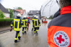 Einsatzkräfte von Feuerwehr und DRK auf überschwemmter Straße