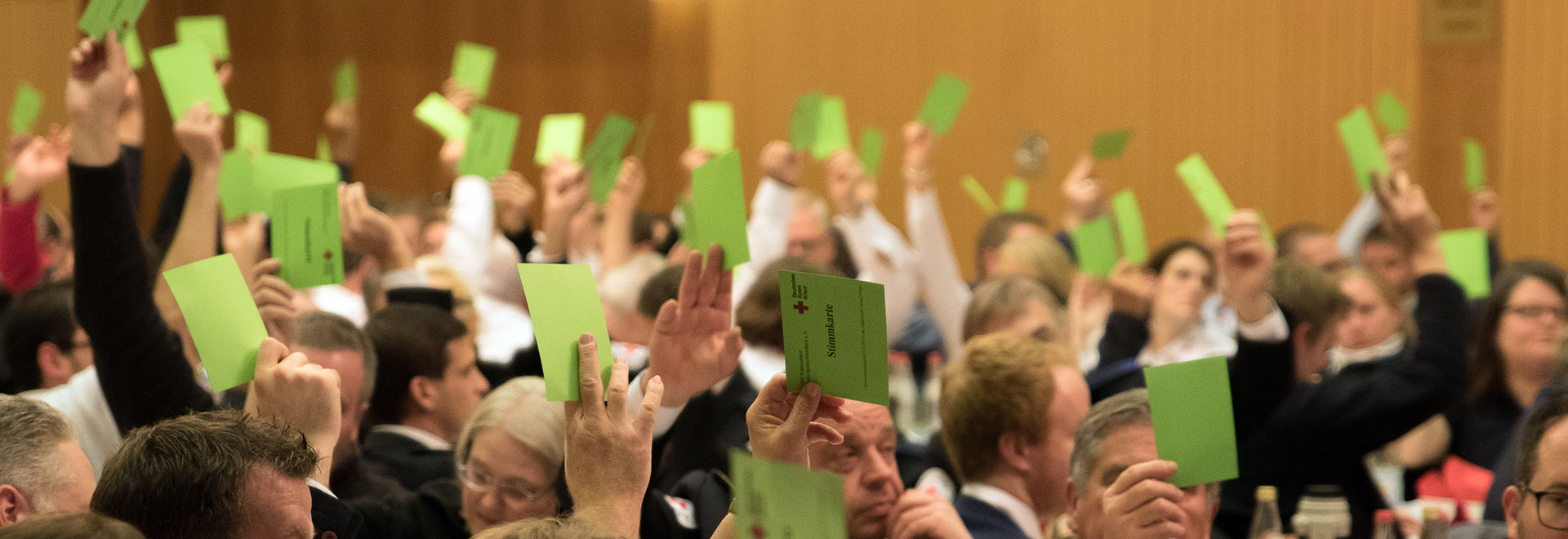 erhobene Hände mit grünen Stimmzetteln