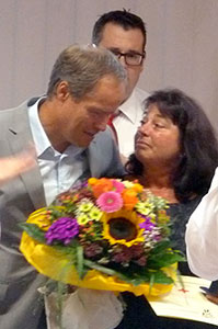 Frau Broghammer erhält von Herrn Dr. Würzner einen Blumenstrauß und eine Medaille