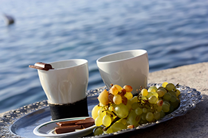 Kaffeetassen und Trauben auf einem Tablett am Meer