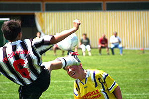 Fussballspieler trifft einen Gegner mit dem Fuss am Kopf