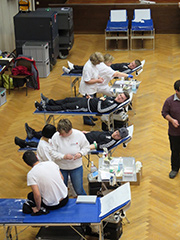 Menschen beim Blutspenden in einer Halle