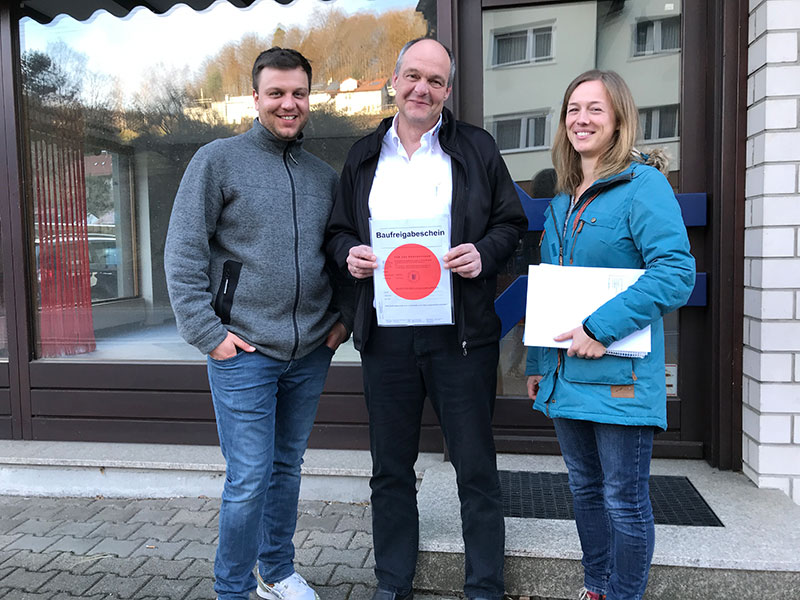 Ralf Dussinger, Patrick Bickel und Henrike Zeilfelder mit dem Roten Punkt der Baugenehmigung