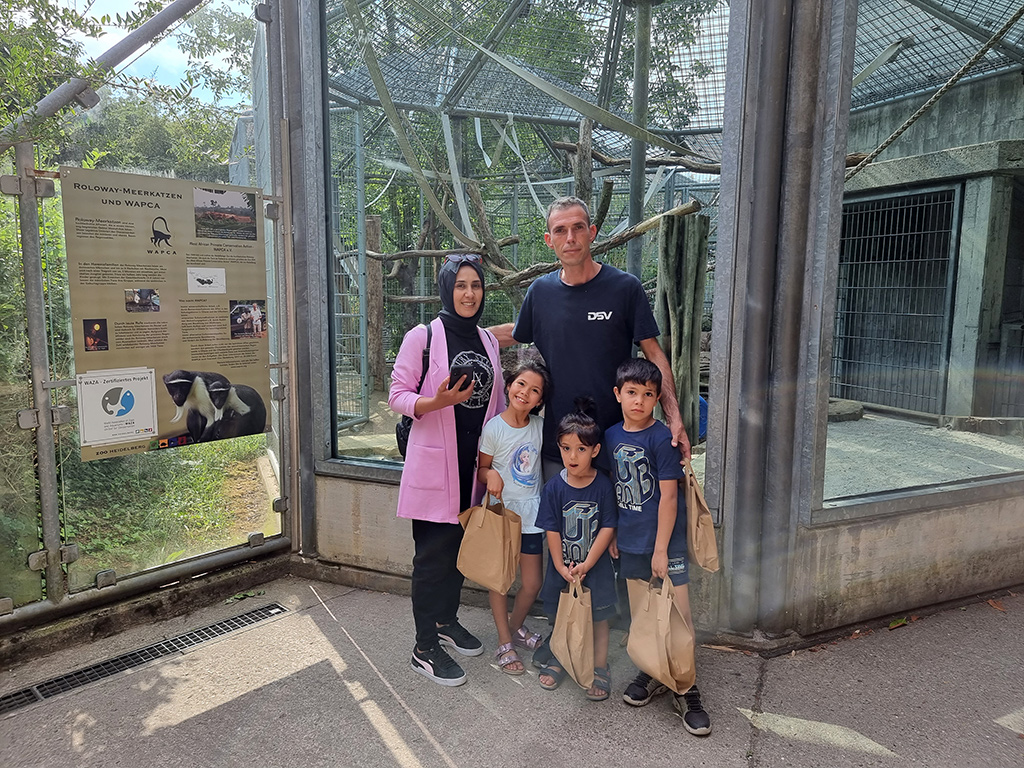 Türkische Familie mit ihren drei Kindern und Lunchpaketen im Affenhaus des Zoos