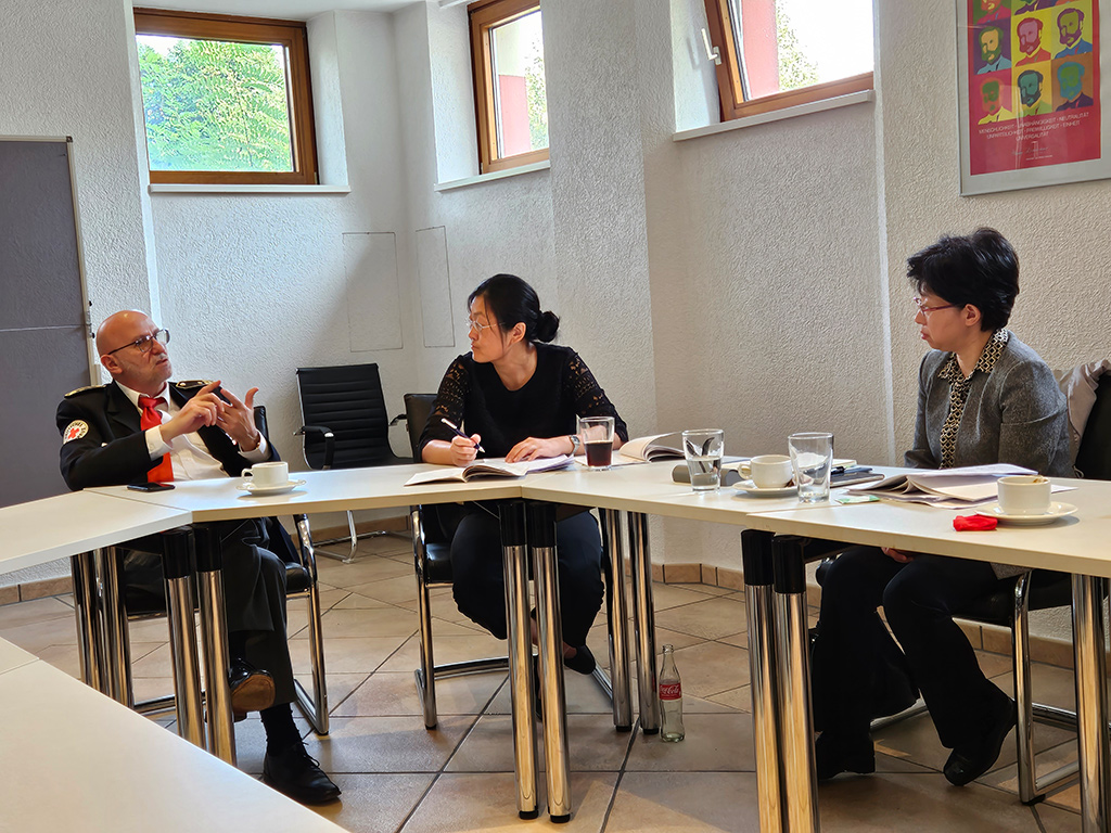 Jürgen Wiesbeck spricht mit zwei Vertreterinnen der Delegation aus China am Besprechungstisch