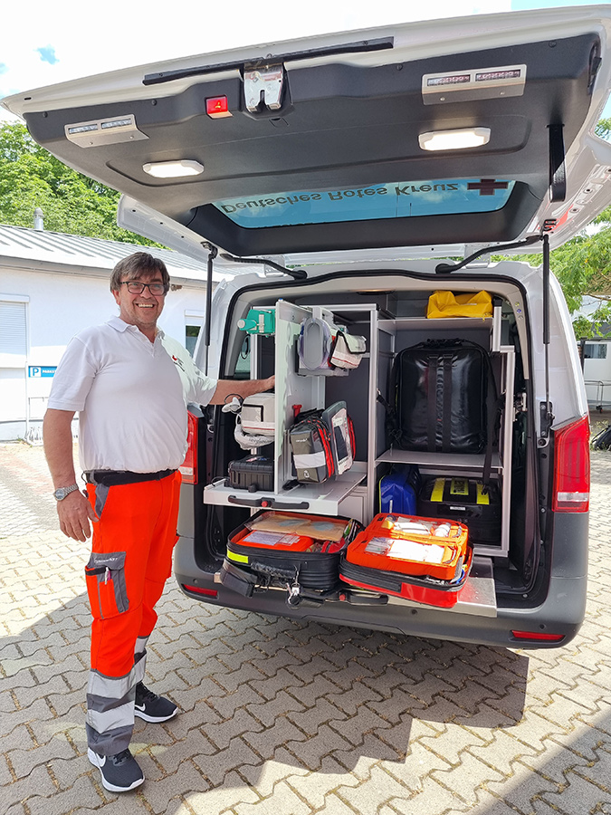 Hugo Groß neben einem geöffneten Heck eines Notarztwagens