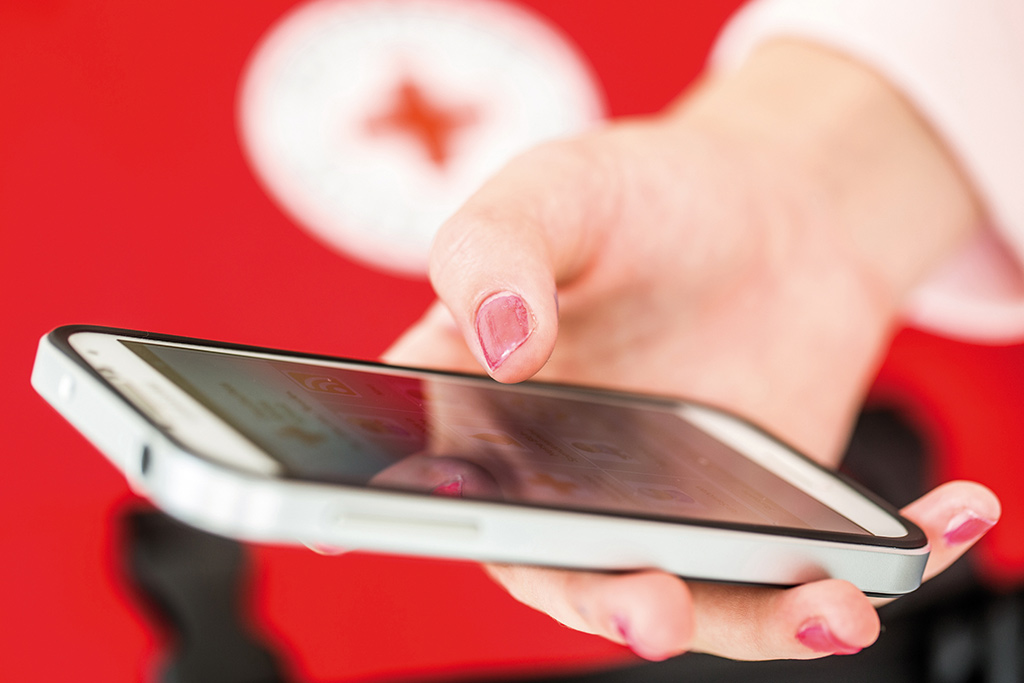 Bild größer ansehen Frauenhand hält ein Smartphone; Foto: A. Zelck / DRK