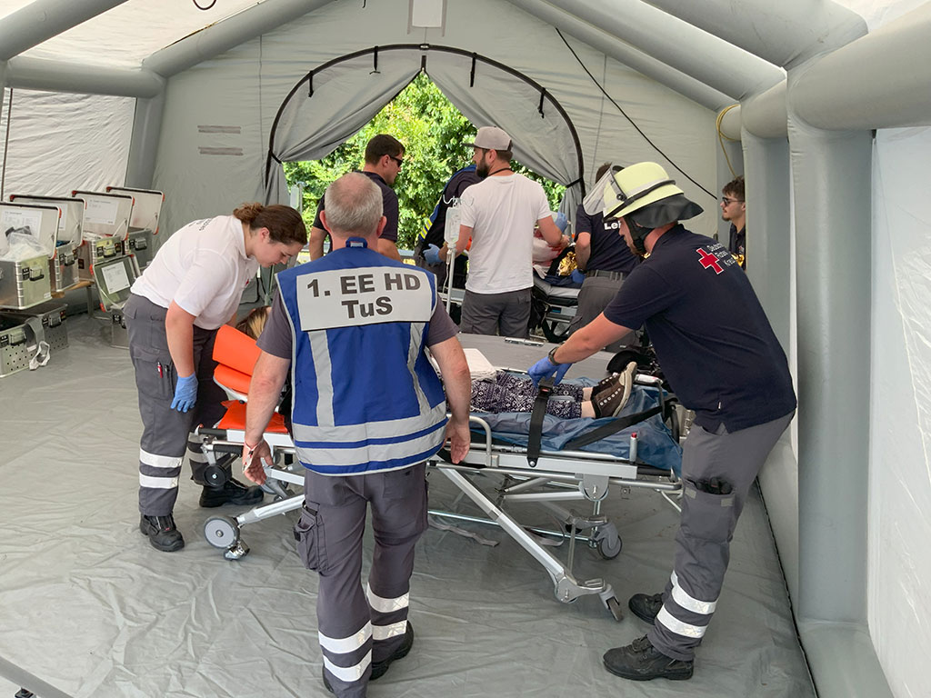 Eine verletzte Person wird in einem Zelt von Sanitätern versorgt