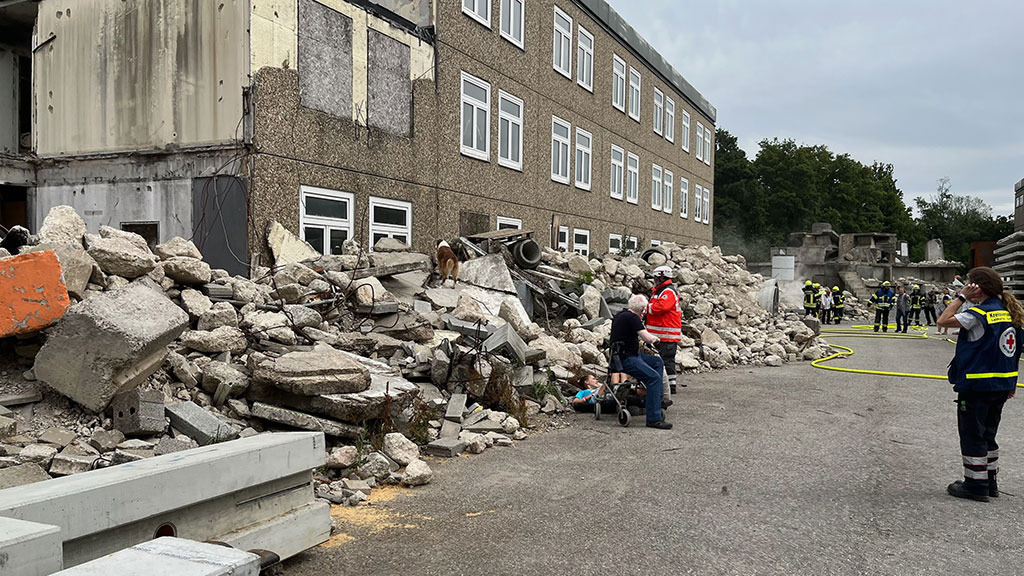 Versorgung einer verletzten Person neben einem großen Schuttberg