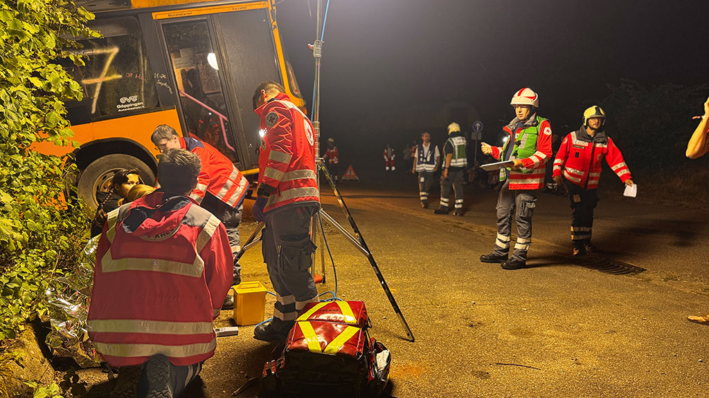 Rettungssanitäter neben einem verunglückten Bus in der Nacht
