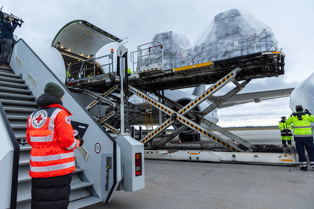 DRK-Mitarbeiter neben einem Flugzeug, in dem Hilfsgüter in den Nahen Osten gebracht werden. Foto: Moritz Meyer / DRK