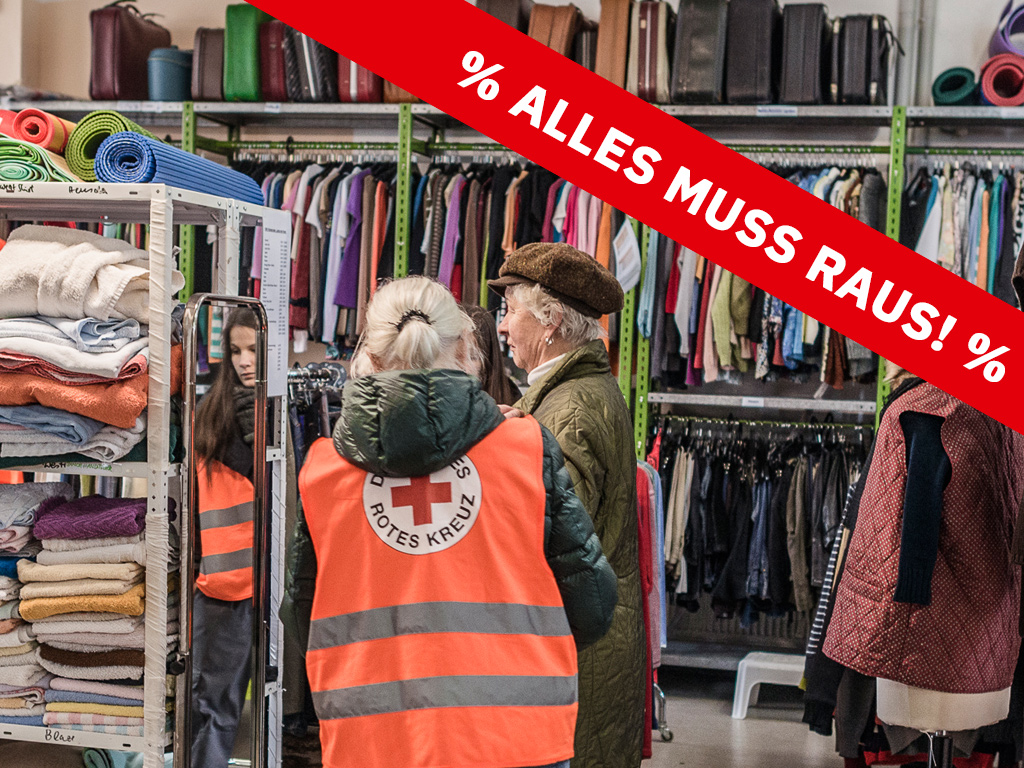 Blick in den Kleiderladen mit Schriftband Alles muss raus!