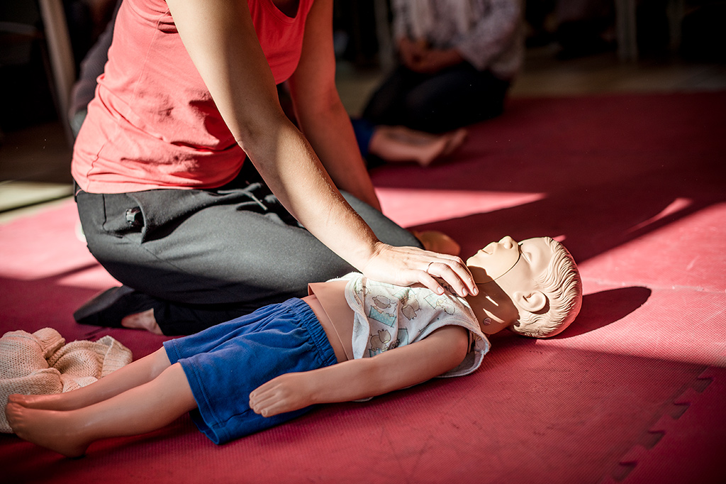 Jemand übt an einer Kinderpuppe Reanimation