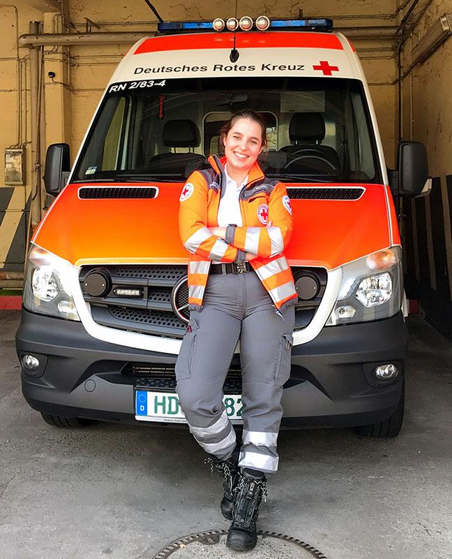 Notfallsanitäterin Rebekka vor einem Rettungswagen