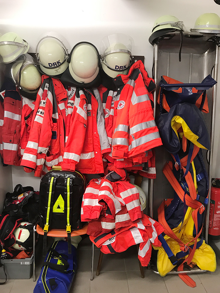 Jacken und Helme hängen an der Wand