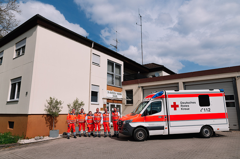 Rettungssanitäter und Fahrzeug vor dem Gebäude der Rettungswache Eberbach