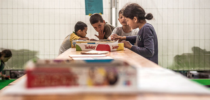 Flüchtlingskinder spielen an einem Tisch