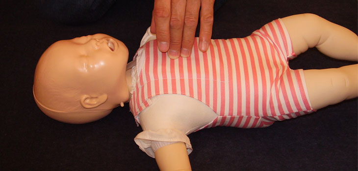 Herzmassage bei einer Baby-Puppe