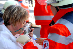 Sanitäter legt bei einer Frau eine Sauerstoffmaske an