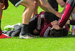 Verletzter Fußballspieler liegt auf dem Rasen