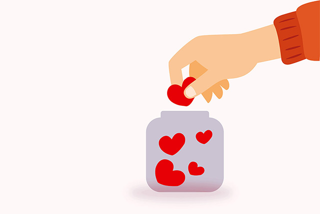 Hand, die Herzen in ein Glas wirft