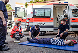 Erste Hilfe Übung vor einem Rettungswagen