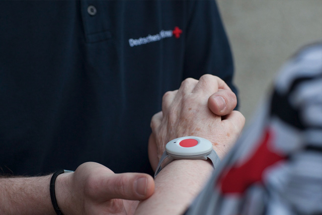 Hausnotrufknopf am Handgelenk einer älteren Dame