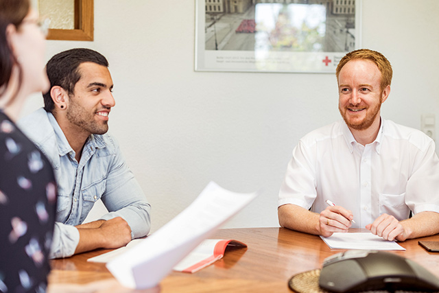 Übersicht über Jobangebote Mitarbeiter des DRK sitzen am Tisch