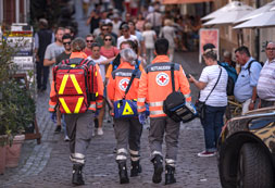 Drei Mitarbeiter des Rettungsdienstes gehen durch eine Fußgängerzone